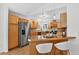 Bright kitchen area with stainless steel refrigerator, wood cabinets and hardwood floors at 5193 Rustic Ave, Firestone, CO 80504