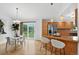 Open kitchen and dining area featuring hardwood floors, a breakfast bar, and modern appliances at 5193 Rustic Ave, Firestone, CO 80504