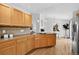 Kitchen area boasts wood cabinets and floors open to the living and dining area with stainless steel refrigerator at 5193 Rustic Ave, Firestone, CO 80504