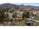 Aerial view showcasing homes with mature trees, lush yards, and mountain backdrop at 25 High St, Palmer Lake, CO 80133