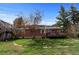 Brick single-story home with a spacious backyard featuring a wooden deck and lush lawn at 25 High St, Palmer Lake, CO 80133