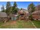 Backyard featuring mature trees, lush lawn, deck, and a cozy two-story home at 25 High St, Palmer Lake, CO 80133
