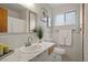 Clean bathroom features a white vanity, a white tiled wall, and natural light, creating a serene atmosphere at 25 High St, Palmer Lake, CO 80133