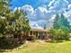 Charming brick home featuring a well-maintained front yard, mature trees, and inviting front porch with seating at 25 High St, Palmer Lake, CO 80133