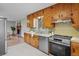 Bright kitchen featuring wood cabinets, stainless steel appliances, and open access to the dining area with fireplace at 25 High St, Palmer Lake, CO 80133