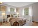 Well-lit main bedroom with hardwood floors, neutral walls, and multiple windows dressed with sheer curtains at 25 High St, Palmer Lake, CO 80133