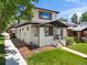 Two-story home with a covered front porch, white brick accents, tidy landscaping, and a well-maintained lawn at 400 S Gilpin St, Denver, CO 80209