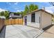 Detached white brick garage with concrete driveway and new wooden fence under a bright blue summer sky at 400 S Gilpin St, Denver, CO 80209