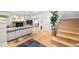 Open living room featuring light hardwood floors, a fireplace, and a staircase with wooden steps at 400 S Gilpin St, Denver, CO 80209