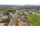 An aerial view showing a quiet neighborhood, green space, and distant mountains in the background at 1155 W 4Th Ave, Broomfield, CO 80020