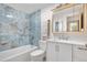 Updated bathroom with marble blue tile, modern vanity, mirror and shower-tub combination at 1021 Carr St # 37, Lakewood, CO 80214