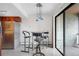 Modern dining area with a glass table, bar stools, pendant lighting, and sliding glass doors to the outside at 1021 Carr St # 37, Lakewood, CO 80214