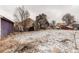 Backyard covered with light snow showing the detached garage and house at 634 S Hazel Ct, Denver, CO 80219