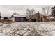 Large backyard partially covered in snow with detached garage and house at 634 S Hazel Ct, Denver, CO 80219