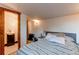 Bedroom with striped bedding, side table, lamp and en suite bathroom with patterned tile floor at 634 S Hazel Ct, Denver, CO 80219