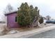 Side view of the home with mature trees and a detached garage, providing extra parking or storage at 634 S Hazel Ct, Denver, CO 80219