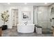 Modern bathroom featuring a soaking tub, walk-in shower with gray tiles and a decorative plant at 555 Coal Bank Trl, Castle Rock, CO 80104