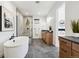 Bright bathroom with a glass shower, soaking tub and wooden vanity featuring modern fixtures at 555 Coal Bank Trl, Castle Rock, CO 80104