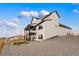 Beautiful two-story home with white siding, black trim, a back deck and backyard area at 555 Coal Bank Trl, Castle Rock, CO 80104