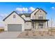 Charming two-story home featuring stone accents, a gray garage door, and a welcoming front porch at 555 Coal Bank Trl, Castle Rock, CO 80104