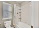 Bright bathroom features a shower-tub combo, white tile, and convenient storage shelves at 226 N Millbrook St, Aurora, CO 80018