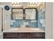 Bathroom featuring double sink vanity with modern fixtures, tile backsplash, and matching mirrors at 226 N Millbrook St, Aurora, CO 80018