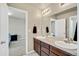 Bathroom featuring a double sink vanity, mirror and access to the bedroom at 226 N Millbrook St, Aurora, CO 80018