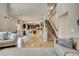 Open concept living room with hardwood floors flowing into a modern kitchen with a staircase at 226 N Millbrook St, Aurora, CO 80018