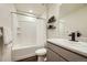 Bright bathroom features a shower-tub combo, gray vanity with black faucet, and stylish shelves at 7024 Kali Ct, Frederick, CO 80530
