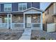 Close-up of a townhome's entrance with stone detailing and a covered front porch at 7024 Kali Ct, Frederick, CO 80530