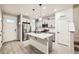 Well-lit kitchen with a large center island, stainless steel refrigerator, and modern fixtures at 7024 Kali Ct, Frederick, CO 80530