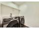 Modern laundry room equipped with Samsung washer and dryer units and white shelves at 7024 Kali Ct, Frederick, CO 80530