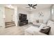 Comfortable living room featuring a large TV, a ceiling fan, and access to the staircase at 7024 Kali Ct, Frederick, CO 80530