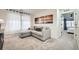 Cozy sitting area with a gray sectional couch, carpet flooring, and natural light from the windows at 7024 Kali Ct, Frederick, CO 80530