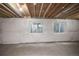 Unfinished basement with exposed ceiling and two bright windows at 17600 Rose Heath Ln, Parker, CO 80134