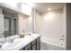 Beautiful bathroom featuring a double vanity, large mirror and shower-tub combination at 17600 Rose Heath Ln, Parker, CO 80134