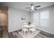 Bright dining area features a modern white table and chairs, a ceiling fan, and wood-look floors at 17600 Rose Heath Ln, Parker, CO 80134