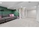Open basement with neutral carpet, a cozy sofa, projector, and access to stairs and a closet at 5555 E Briarwood Ave # 1404, Centennial, CO 80122