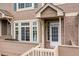 Close-up of a townhome entrance with a white door, bright windows, and a cozy, private deck area at 5555 E Briarwood Ave # 1404, Centennial, CO 80122