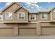 Townhome garages featuring attached units with neutral exteriors and brick accents, providing convenient parking at 5555 E Briarwood Ave # 1404, Centennial, CO 80122
