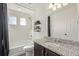 Bathroom with a shower/tub combination, white tile and a granite countertop at 1079 Larkspur Dr, Erie, CO 80516