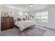 Bright bedroom featuring carpet, three small windows, and a larger window with blinds at 1079 Larkspur Dr, Erie, CO 80516