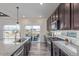 Well-lit kitchen featuring granite countertops, stainless steel appliances, and a sliding glass door at 1079 Larkspur Dr, Erie, CO 80516