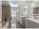 Modern bathroom with dual vanities, stylish tiled flooring, a bath and shower, and a bright skylight at 15207 W Ellsworth Pl, Golden, CO 80401