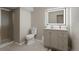 Modern bathroom featuring a lighted mirror, a vanity with sink and storage, and a glass enclosed shower at 15207 W Ellsworth Pl, Golden, CO 80401