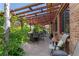 Charming patio with brick flooring, pergola, and lush greenery, creating a tranquil outdoor space at 15207 W Ellsworth Pl, Golden, CO 80401