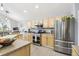 Modern kitchen equipped with stainless steel appliances, light wood cabinetry, and ample counter space for cooking at 15948 E 106Th Pl, Commerce City, CO 80022