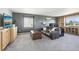 Cozy living room with a leather sofa, built-in shelving and a large window at 15948 E 106Th Pl, Commerce City, CO 80022