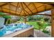 Backyard oasis featuring a hot tub under a wooden pergola and beautifully landscaped surroundings at 21502 E Idyllwilde Dr, Parker, CO 80138