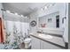 Bathroom with a floral shower curtain, a white vanity, and a decorative mirror at 21502 E Idyllwilde Dr, Parker, CO 80138